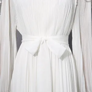 Close-up of elegant pleated white chiffon dress with waist tie bow detail