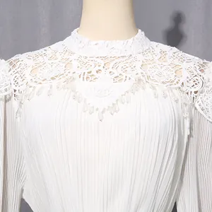 Close-up of white chiffon evening dress featuring intricate lace collar and bead fringe details.