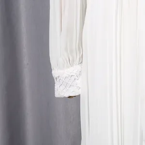 Close-up view of elegant white chiffon dress sleeve showing intricate lace embroidery on the cuff