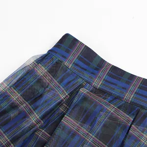 Detailed close-up view of blue plaid mesh fabric on a high-waisted pleated skirt