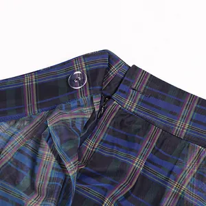 Detail view of a blue plaid mesh skirt showing button and zipper on the high waistband.