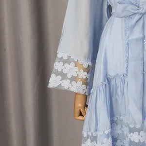 Primer plano de un vestido vintage azul claro con bordado de encaje floral y volantes