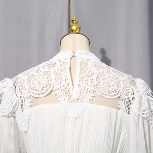 Close-up detail of white chiffon maxi dress featuring intricate floral lace neckline embroidery