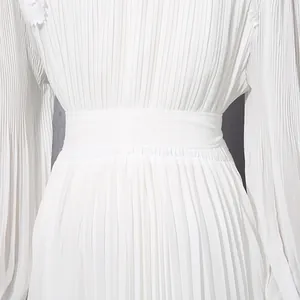 Close-up view of elegant white pleated chiffon dress waist detail and long sleeves
