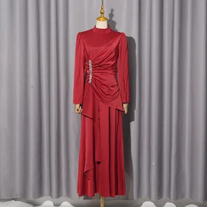 Detailansicht eines eleganten roten Falten-Abendkleids mit glänzenden Kristallakzenten
