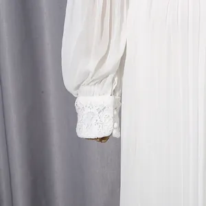 Close-up of elegant white chiffon dress sleeve with delicate lace cuff and button detail