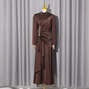 Detailansicht eines braunen Satin-Maxikleids mit Strasssteinen und geraffter Taille
