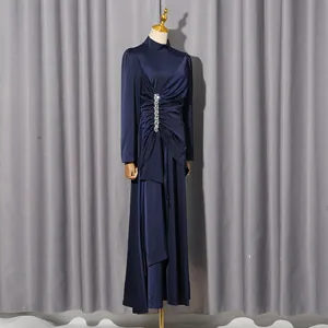 Details des dunkelblauen Langarm-Maxikleids mit eleganten Falten und Strassbesatz.