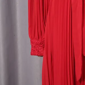 Close-up of elegant red chiffon dress featuring intricate lace embroidery on cuffs