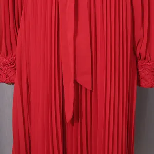 Detailed view of red pleated chiffon evening gown with elegant lace embroidered cuffs