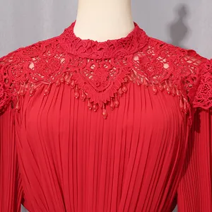 Detailed macro view of red pleated chiffon dress with elegant lace collar and beads