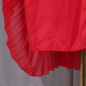 Detail showing the fine pleated hem of an elegant solid red chiffon evening gown