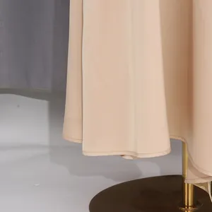 Primo piano dell'orlo della gonna beige con cuciture di alta qualità e trama del tessuto.