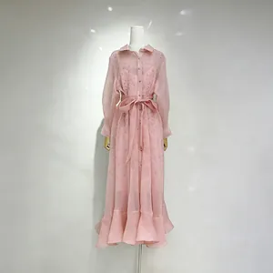 Detail eines eleganten rosa Maxikleides im französischen Stil mit Rüschensaum