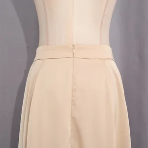 Dettaglio ravvicinato della cerniera invisibile su un'elegante gonna lunga in raso beige