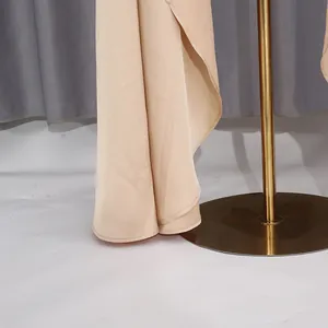 Vista dettagliata dell'orlo della gonna beige elegante che mostra il drappeggio del tessuto.
