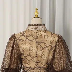 Detail shot showing the back of a snake print vacation dress with brown lace puff sleeves