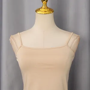Dettaglio delle spalline sottili e della scollatura liscia su un top beige chic