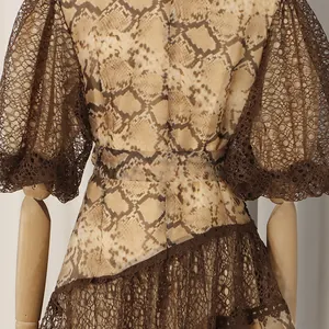 Close-up of French yellow snake print dress with brown lace puff sleeves and waist tie