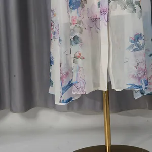 Nahaufnahme des Chiffonstoffs mit Blumendruck am Saum eines Vintage-Kleides.