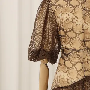 Close-up of brown lace puff sleeves and snakeskin print on a resort style dress