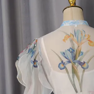 Detailansicht des Vintage-Iris-Blumendrucks auf weißem Chiffonkleid mit Rüschenärmeln