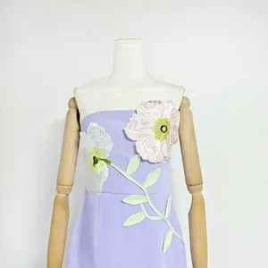 Macro view of 3D pink and white floral embroidery on lavender strapless midi dress