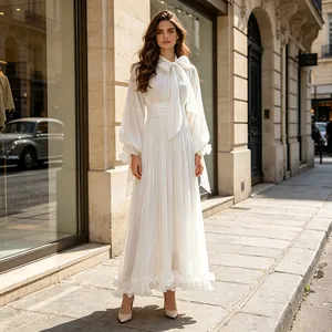 Elegante vestido largo blanco con lazo al cuello y mangas de linterna en la calle.