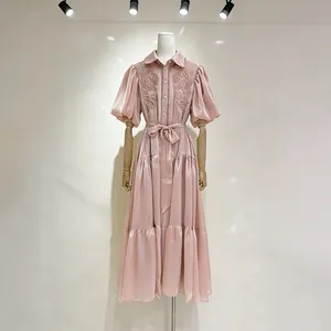 Dettaglio dell'abito lungo stile palazzo vintage con ricamo viola e maniche a sbuffo