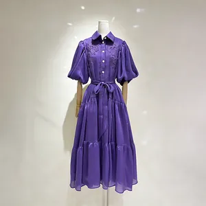 Vista dettagliata di un abito lungo viola ricamato in stile vintage con maniche a sbuffo.