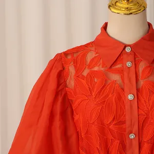 Détail d'une robe chemise brodée rétro française rouge avec manches bouffantes et strass.