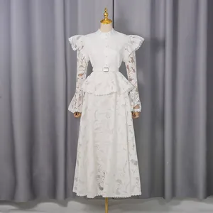 Elegant white embroidered maxi dress with ruffle detailing and long flare sleeves