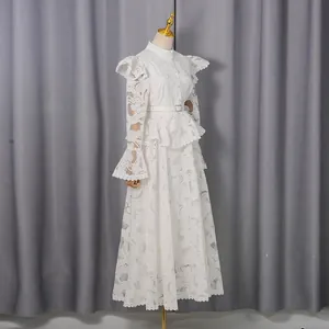 Elegant white lace maxi dress with ruffled shoulders and bell sleeves on a mannequin.