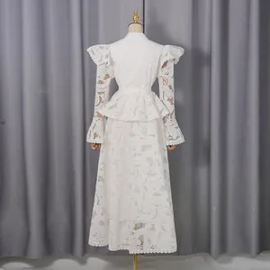 Back view of an elegant white lace maxi dress with ruffles and bell sleeves.