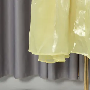 Primo piano del tessuto organza giallo chiaro scintillante su un abito in stile vintage