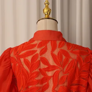 Détail d'une robe vintage orange avec broderies de feuilles et dos en résille ajourée