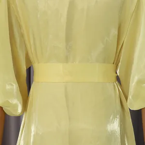 Dettaglio della vita di un abito giallo lucido in stile palazzo vintage raffinato