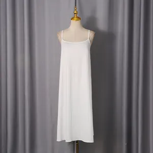 Full view of a white camisole slip dress displayed on a mannequin against grey curtains