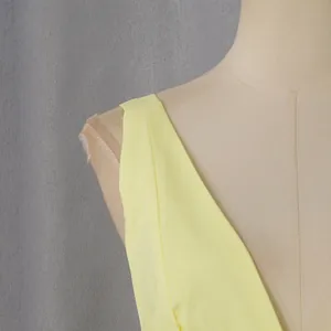 Close-up detail of a light yellow French vintage halter neck dress on a mannequin