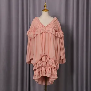 Dettaglio dell'abito rosa a strati con volant e gonna a pieghe in stile palazzo.