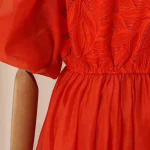 Gros plan sur les broderies rouges et les manches bouffantes d'une robe chemise rétro.