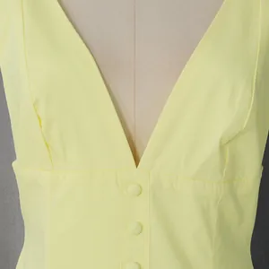 Close-up of deep V-neckline and button detail on a pale yellow French vintage dress.
