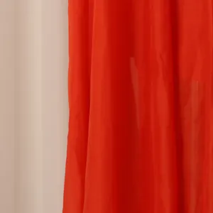 Gros plan sur la texture du tissu rouge vif et les plis d'une robe chemisier vintage