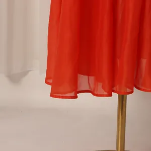 Détail de l'ourlet d'une robe vintage française rouge vif avec des coutures soignées.