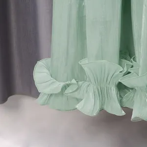 Detalle de cerca de un vestido de hilo fluido verde menta con un elegante dobladillo con volantes