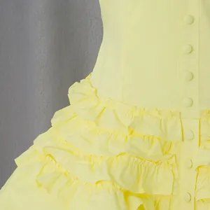 Detail shot of yellow French vintage dress featuring tiered ruffles and covered buttons.