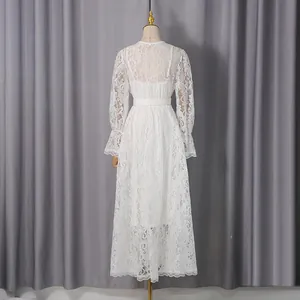 Back view of elegant white lace maxi dress with long sleeves and hollow-out design.