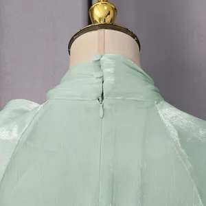 Detalle trasero de vestido brillante verde menta con botones en cuello y cremallera