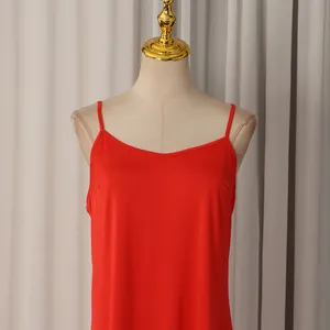 Détail rapproché d'un haut caraco en soie rouge vif exposé sur un mannequin femme.