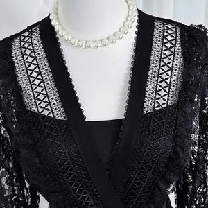 Close-up detail of elegant black hollow lace V-neck retro court style dress with pearls